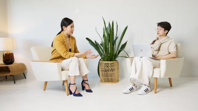 Two people having a casual interview session indoors with minimalist decor and a home plant. Pick SAAS marketing customer interviews that survive scrutiny