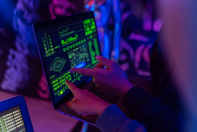 A person analyzing cybersecurity data on a laptop in a dimly lit room. SAAS marketing data protection without the legal fog