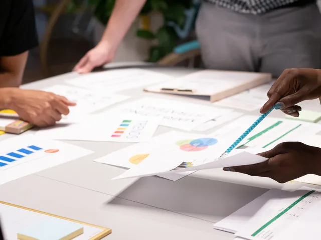 Team analyzing documents and charts during a collaborative office meeting. Seven steps to write a SAAS marketing disclosure policy