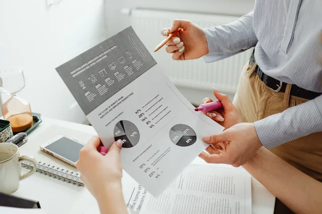 A close-up view of two colleagues analyzing business graphs and charts together. SAAS marketing foundations for England without the guesswork