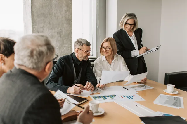 A diverse group of business professionals engaged in a strategic meeting. SAAS marketing team roles and their data sources explained