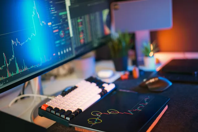 Modern workspace with screens displaying cryptocurrency market data and trends. SaaS marketing implementation workflow for UK teams
