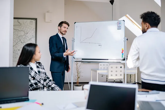 Business team in office presenting growth graph on a whiteboard for strategy discussion and teamwork insights. A 2027 SAAS marketing outlook built on scenarios rather than forecasts